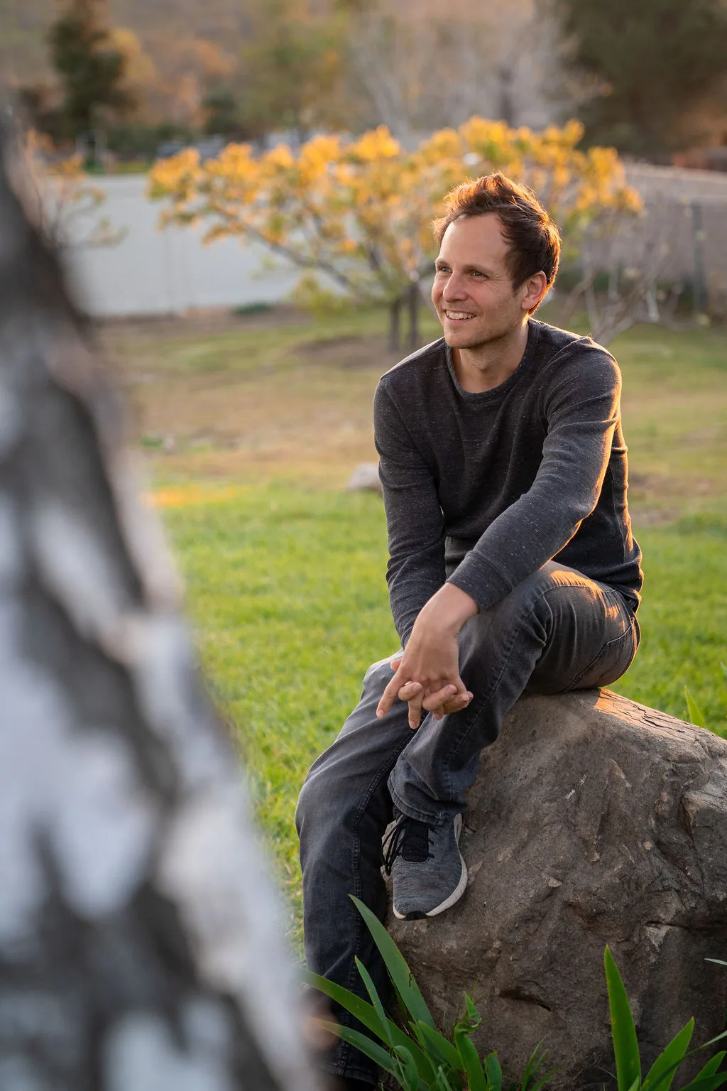 Man sitting on a rock at golden hour, casual outdoor portrait in Southern California