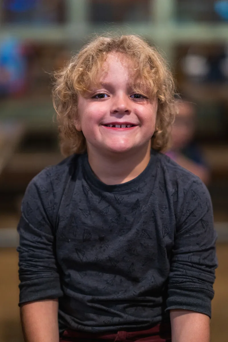 Young child with curly hair smiling, children's portrait photography Southern California